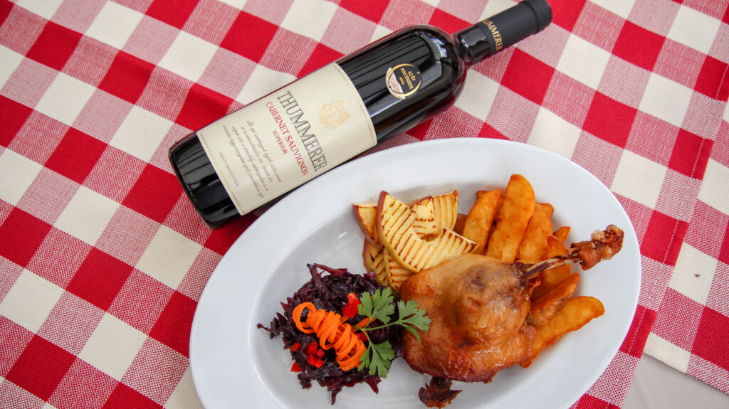 Egy palack Egri Cabernet Sauvignon Superior 2021 bor pkinikezéskor egy tál étel mellett.