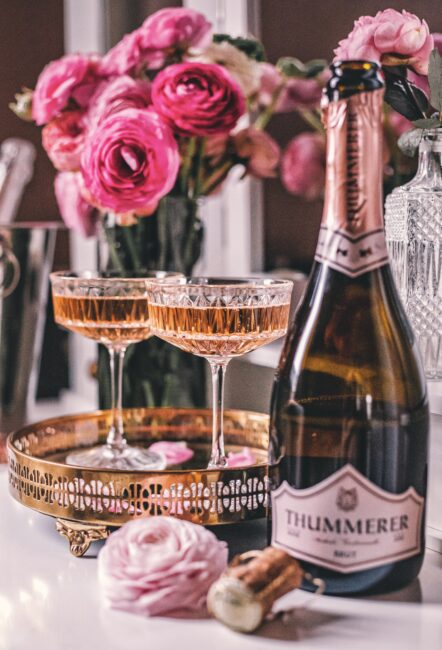 Egy palack Rosé Brut Nature 2017 pezsgő, két kitöltött pezsgős pohárral.